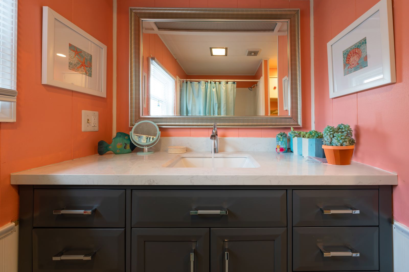 Bathroom with coral walls and navy vanity