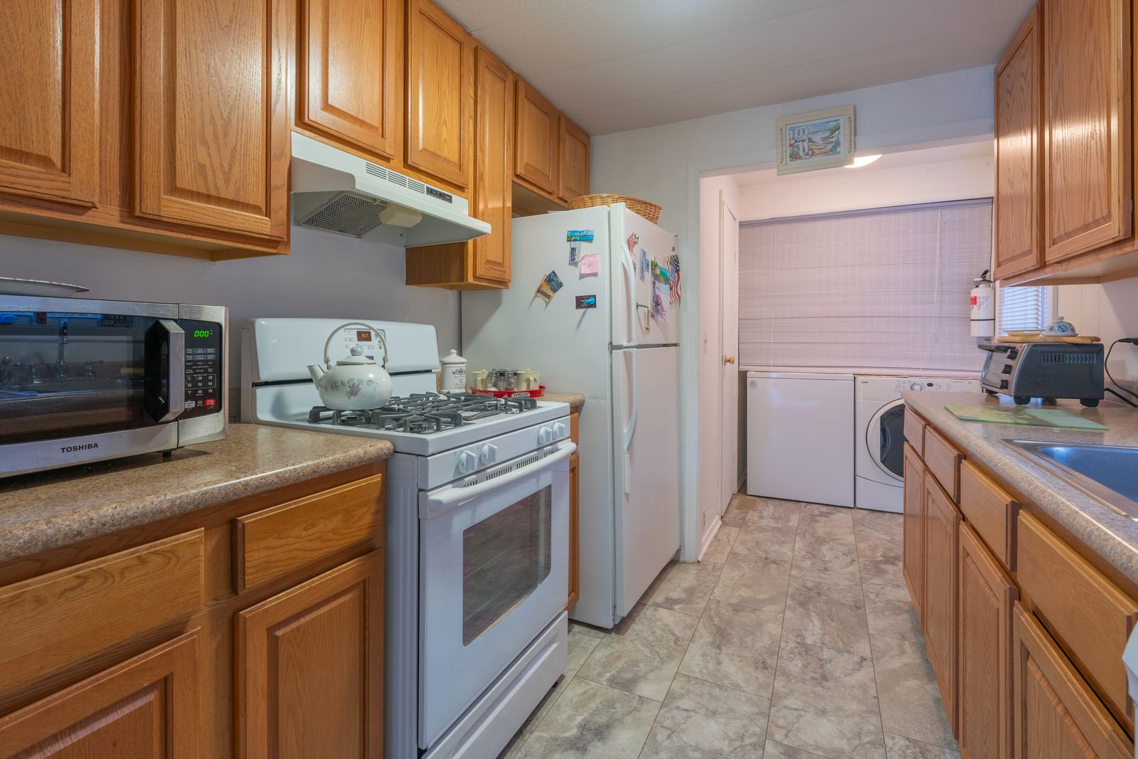 Galley kitchen with oak cabinets and gas range