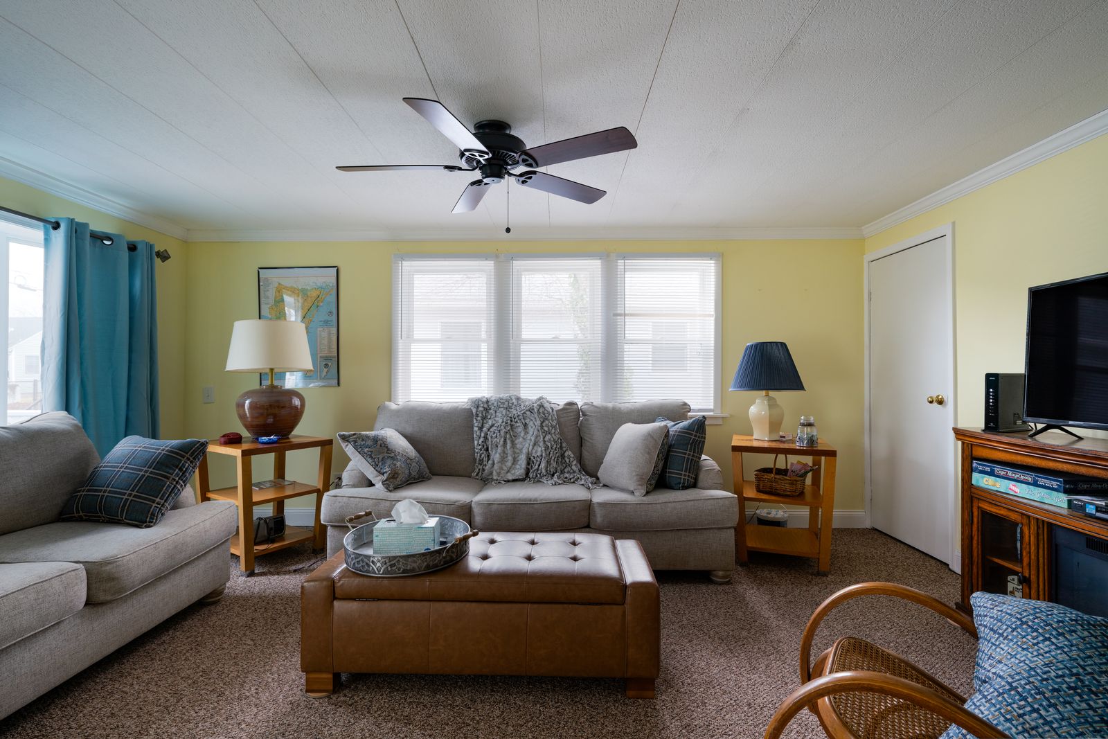 Living room with ceiling fan and bright windows