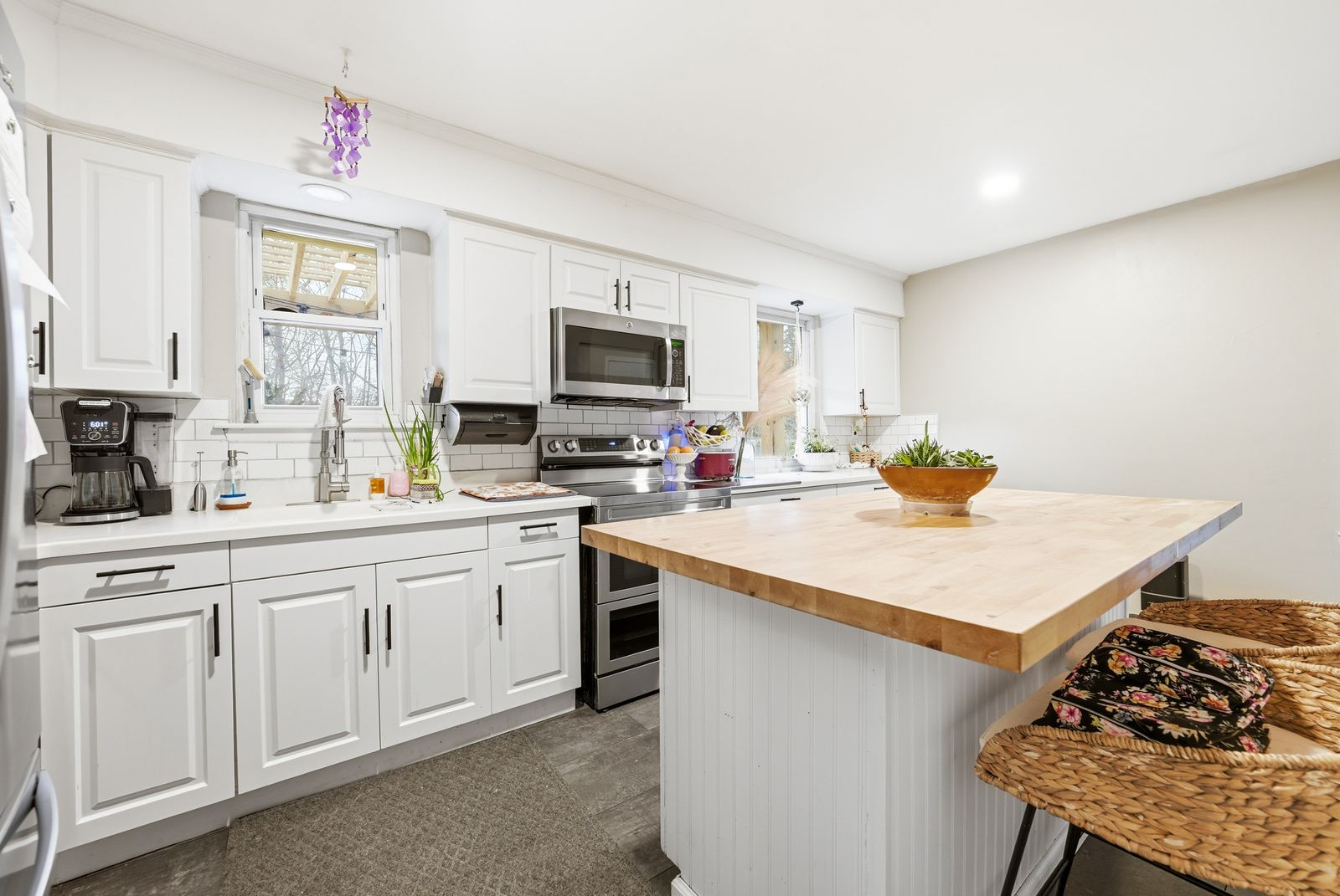 White kitchen with butcher block island and stainless appliances