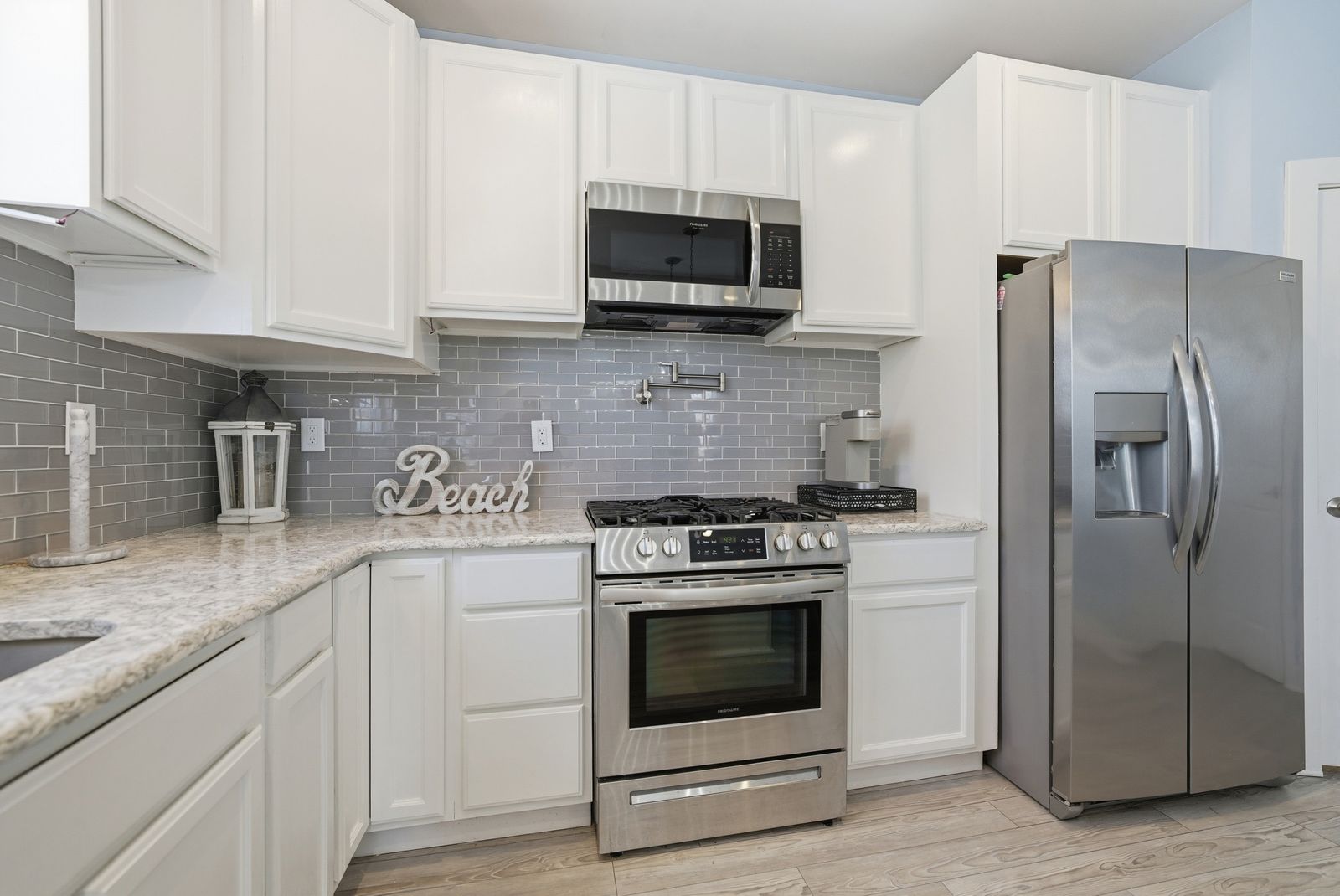 White kitchen with granite counters and stainless appliances