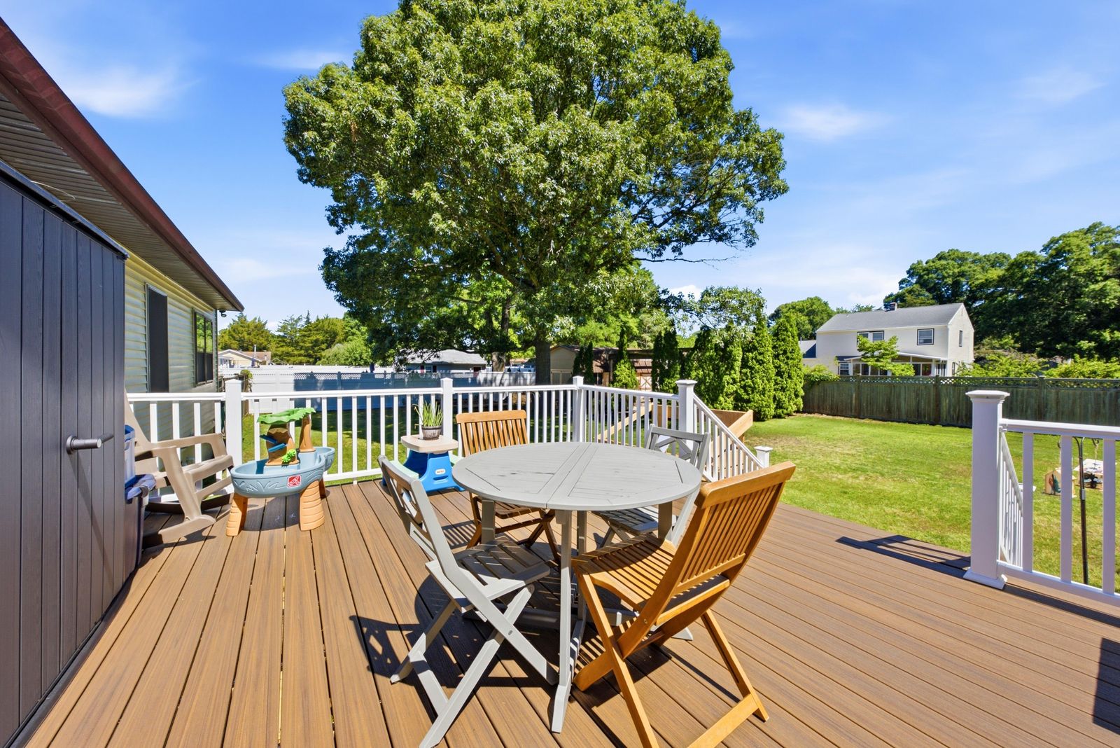 Back deck with white railings and outdoor table overlooking the yard in Cape May Court House NJ