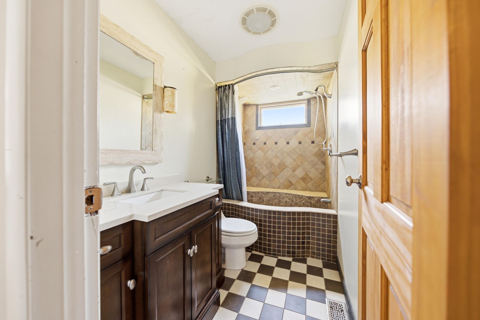 Bathroom with tiled tub and shower, dark wood vanity and checkerboard floor in Cape May Court House NJ