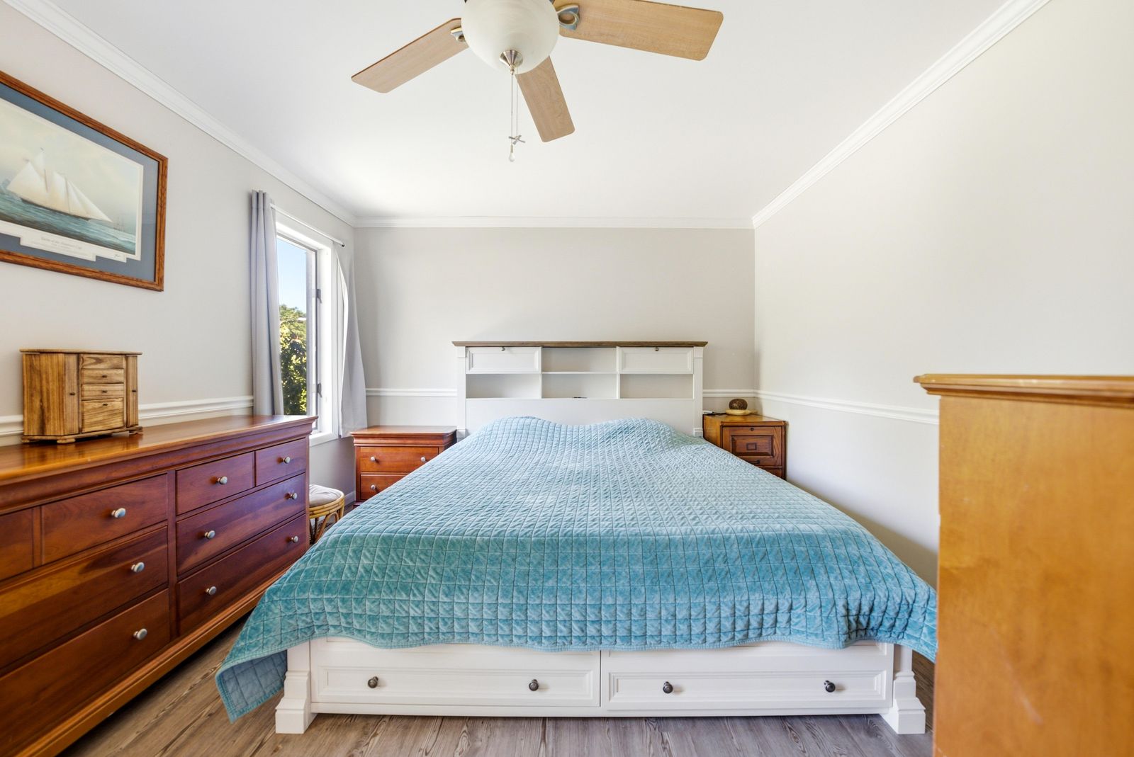 Bedroom with white storage bed, crown molding and ceiling fan in Cape May Court House NJ