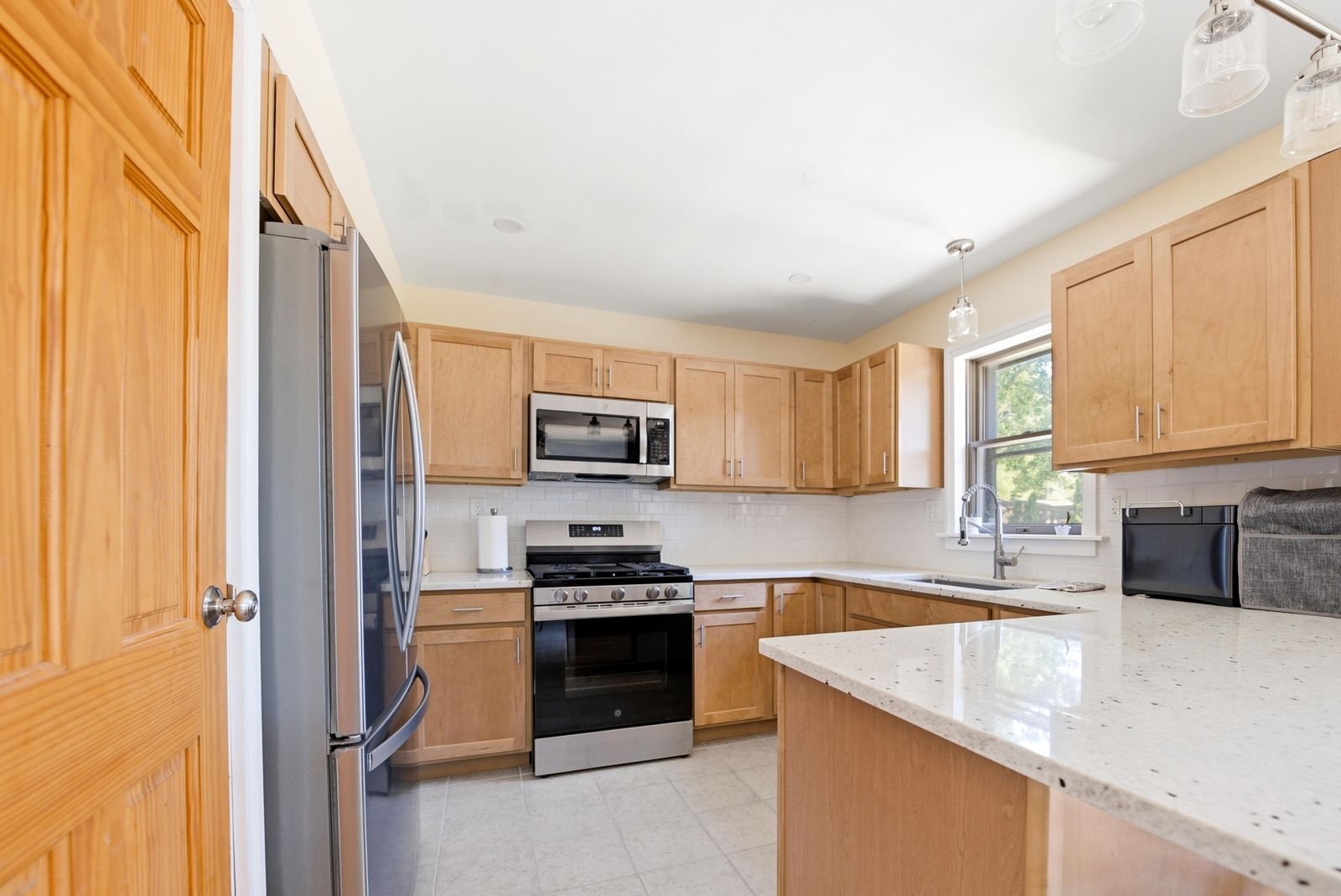 Kitchen with maple cabinets, white subway tile and stainless gas range in Cape May Court House NJ