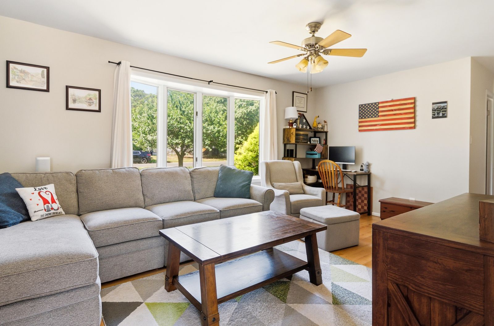 Living room with gray sectional, large front window and ceiling fan in Cape May Court House NJ