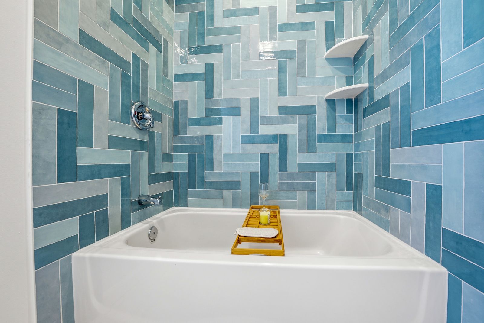 Soaking tub with teal herringbone tile