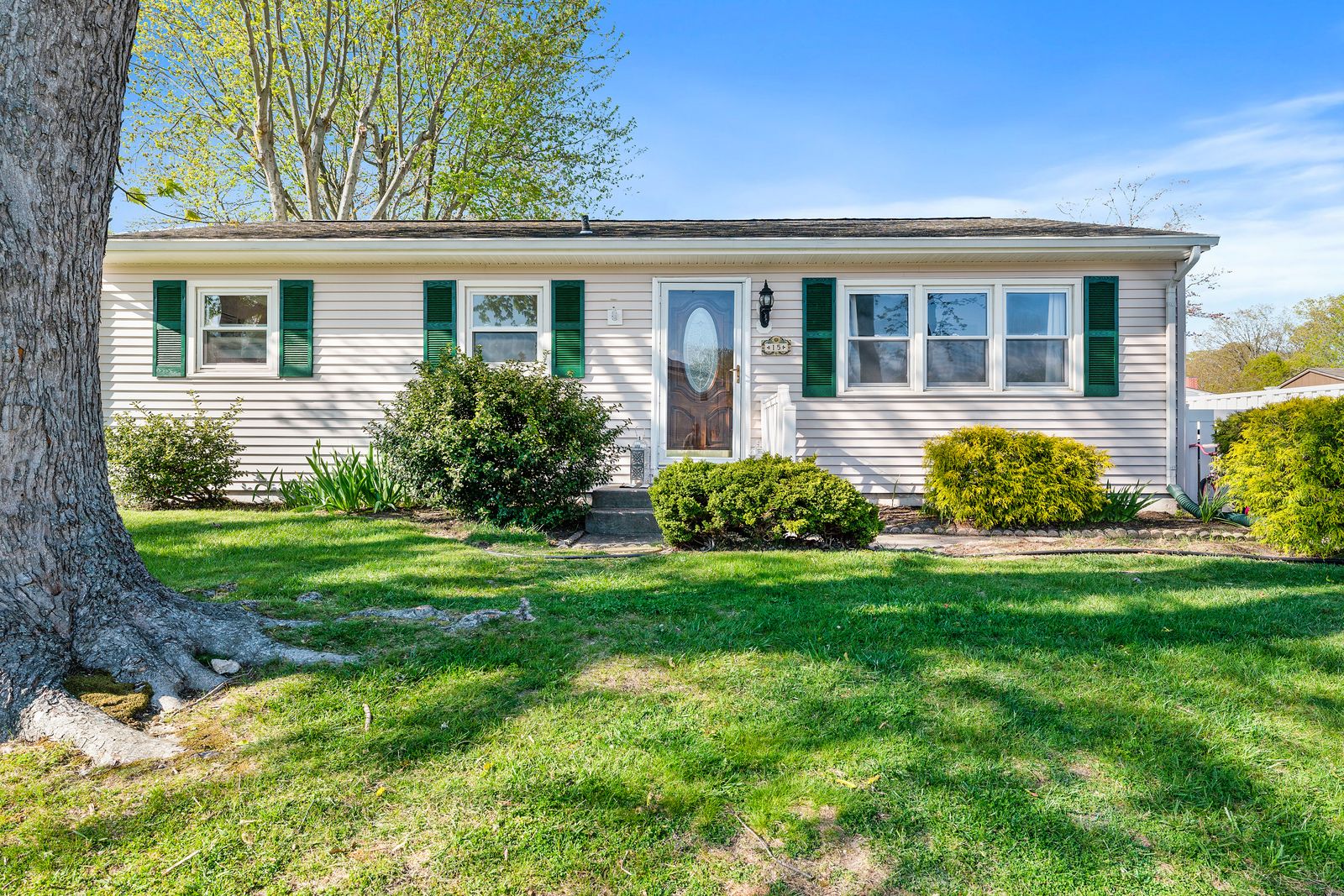 Ranch home with green shutters and shade trees in North Cape May NJ