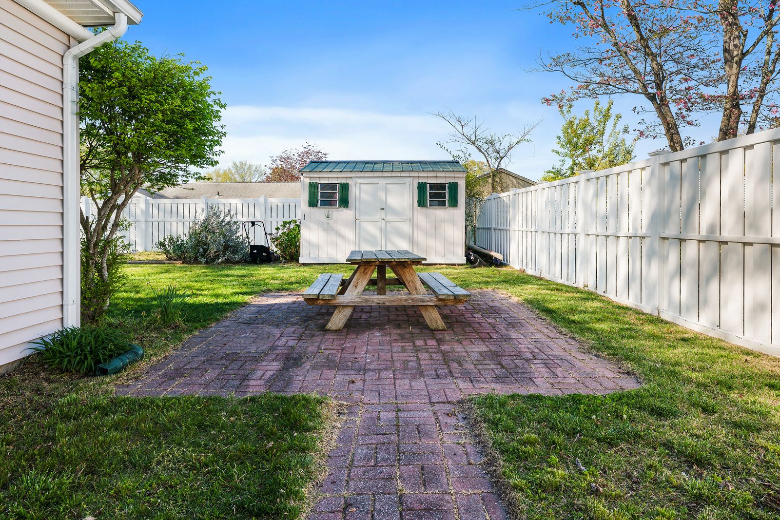 Brick patio with picnic table and fenced yard