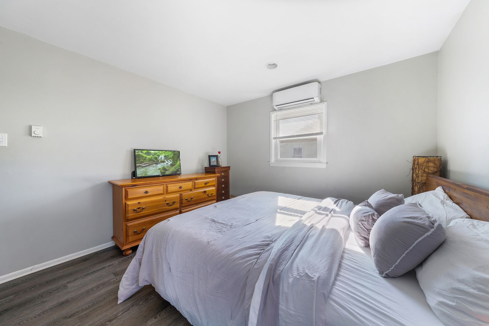 Primary bedroom with wood dresser and mini-split