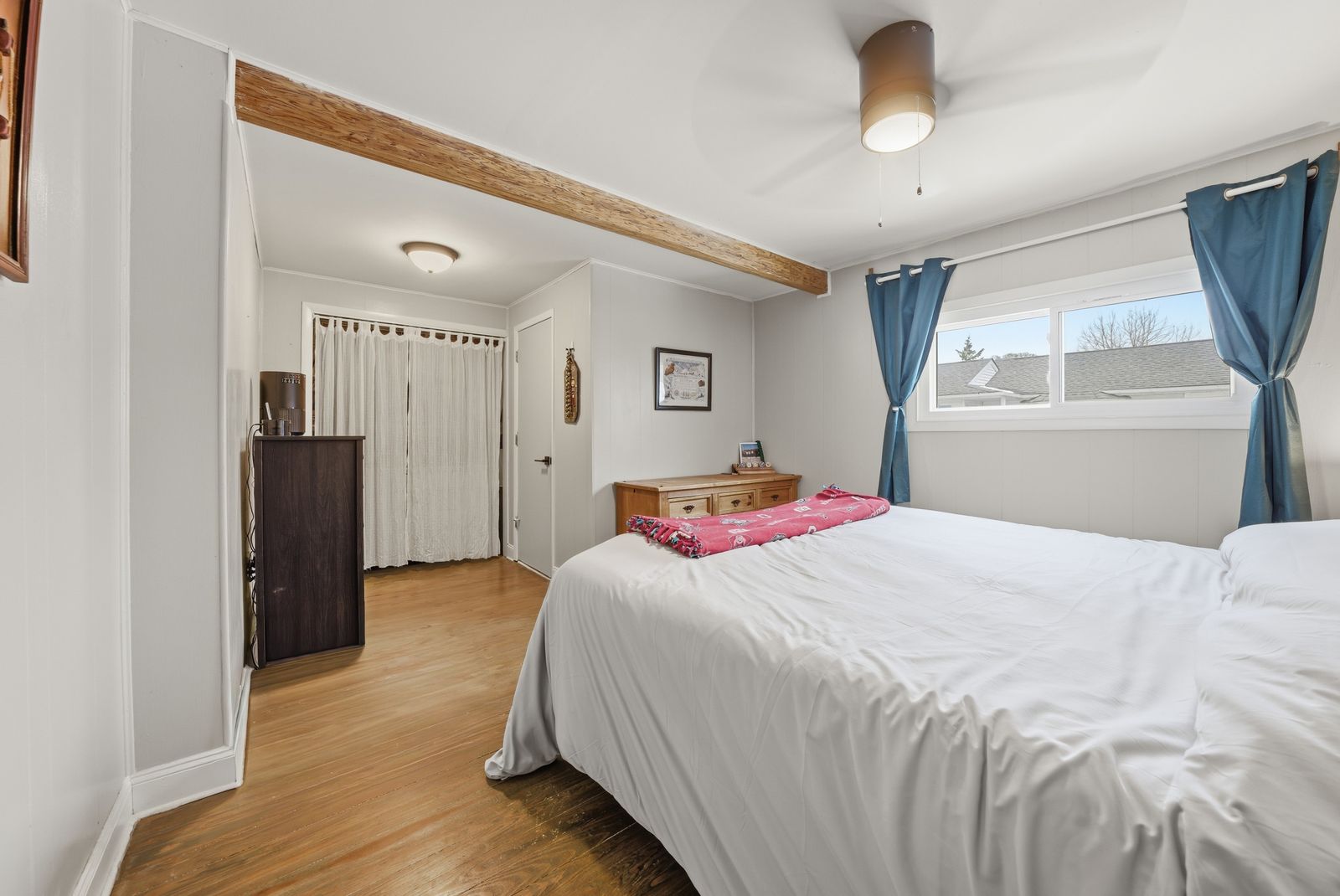 Bedroom with blue curtains and wood accent beam