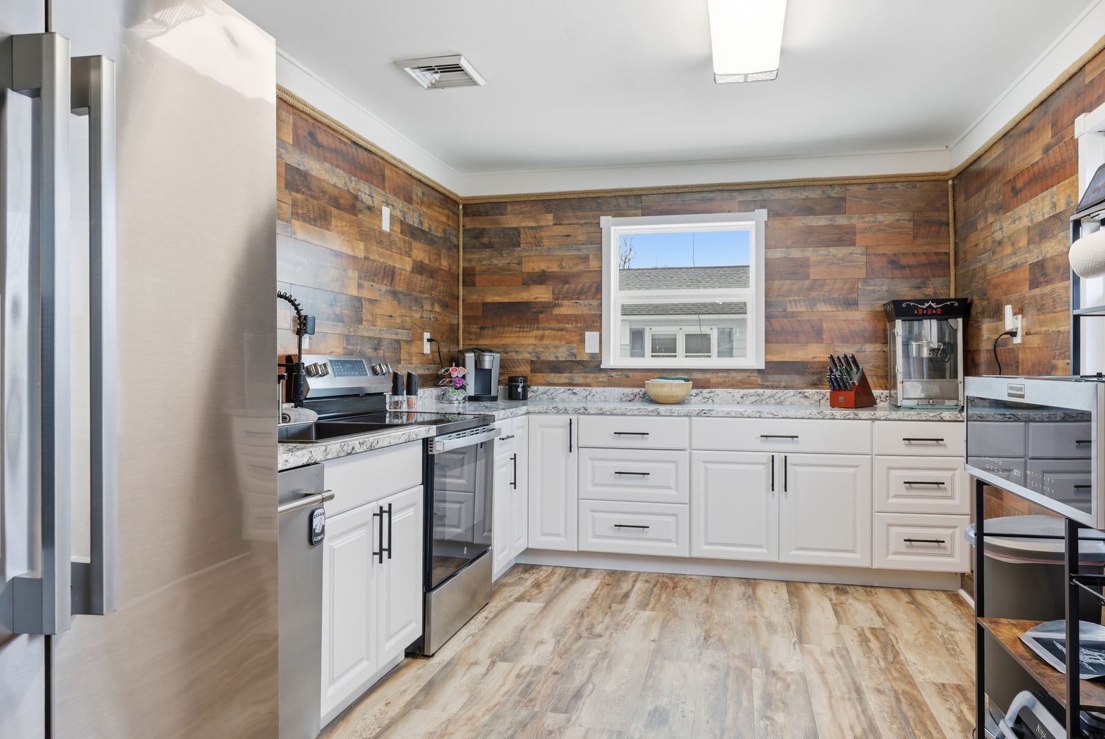 Kitchen with white cabinets and reclaimed wood accent wall