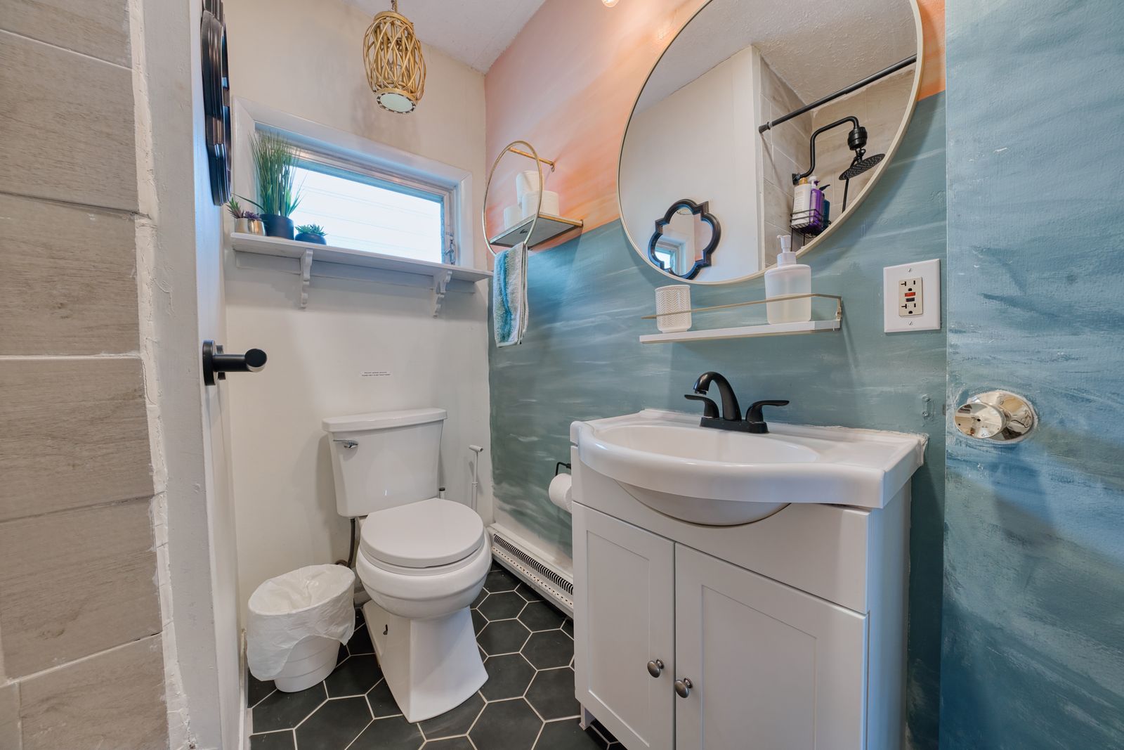 Bathroom with round mirror and coastal wood-look tile