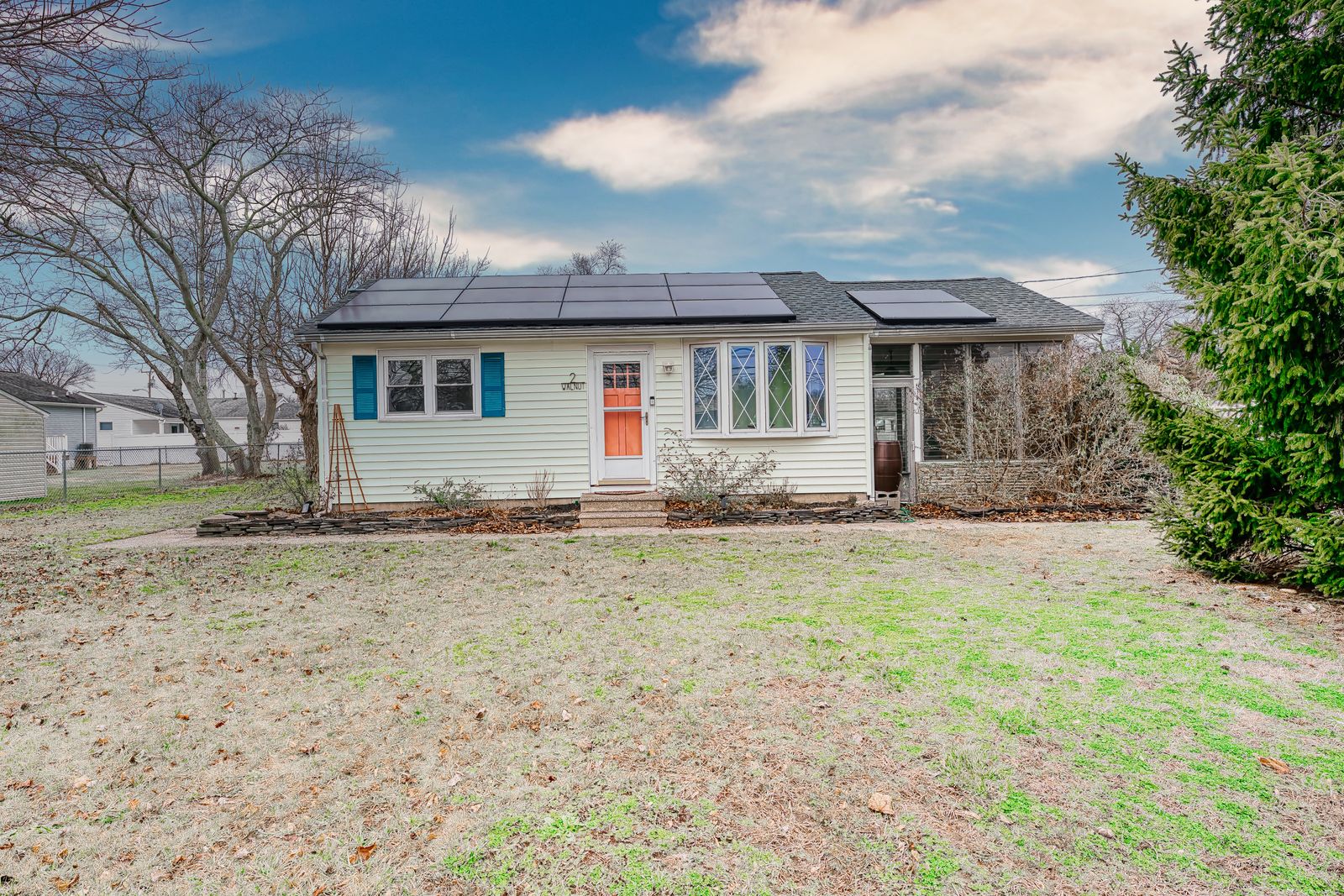 Ranch home with coral front door and solar panels in Villas NJ