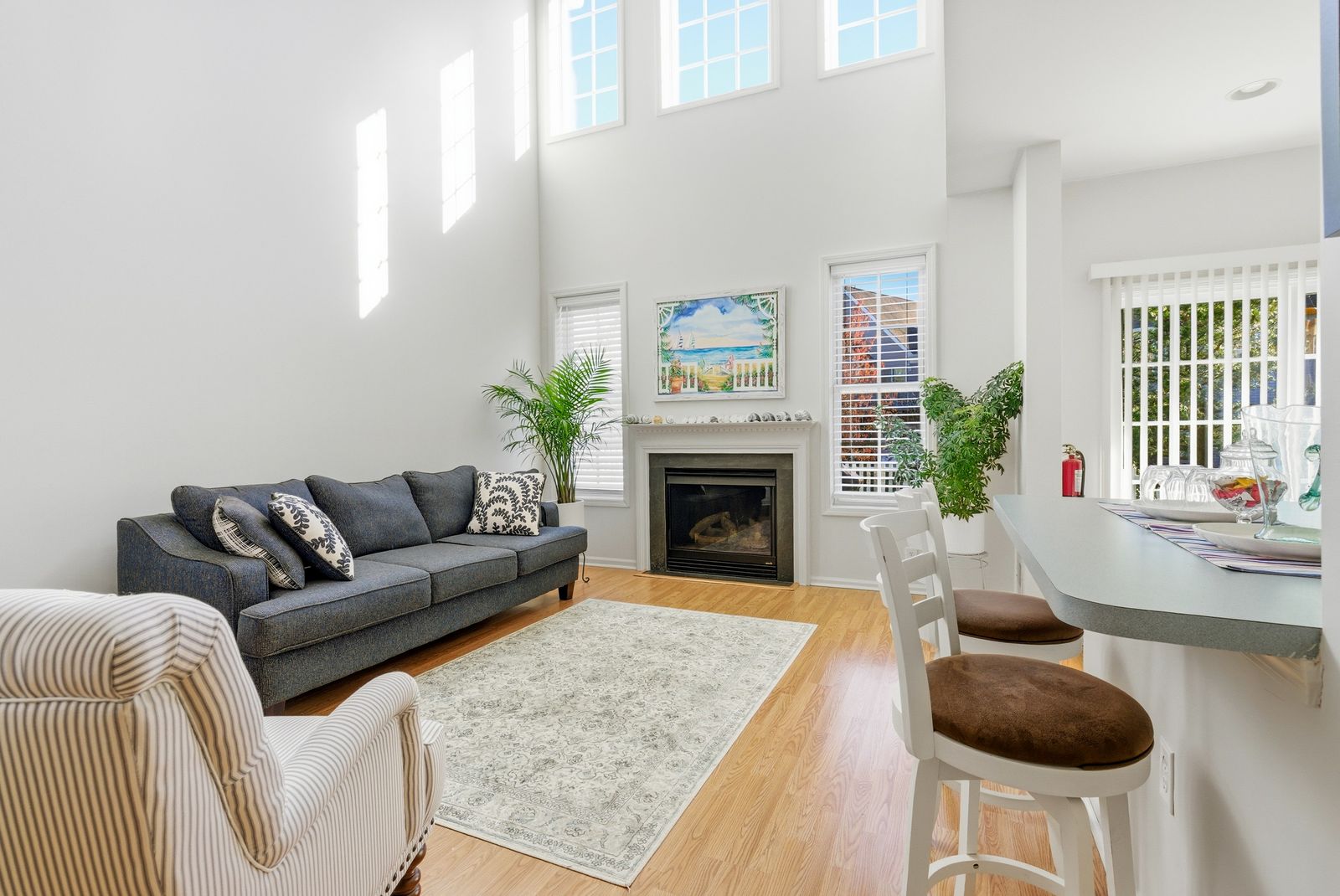 Two-story living room with gas fireplace and tall windows