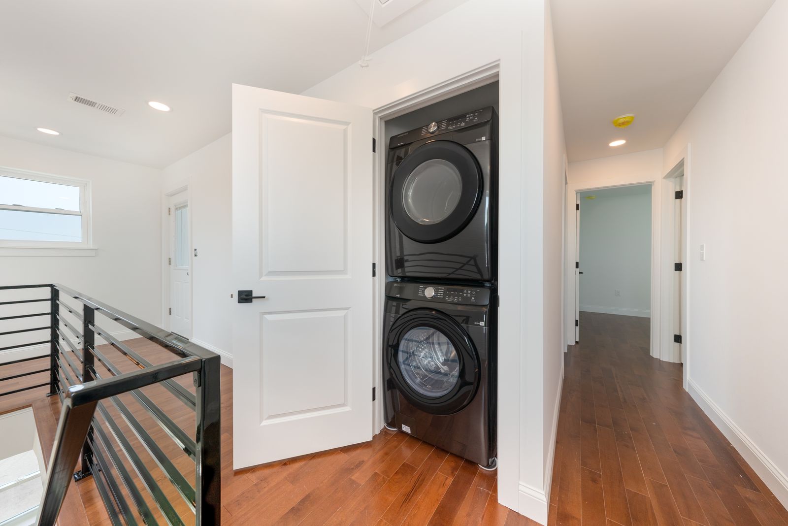 Stacked laundry and modern black stair railing