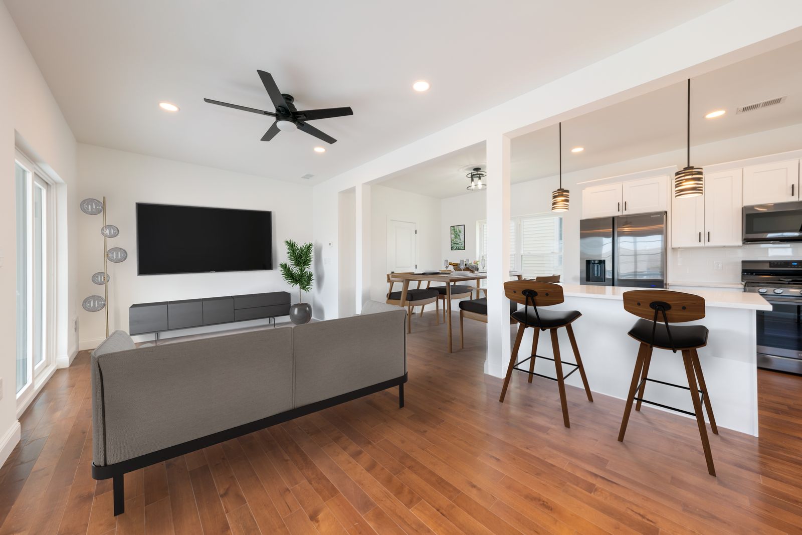 Open living room with hardwood floors and kitchen island seating