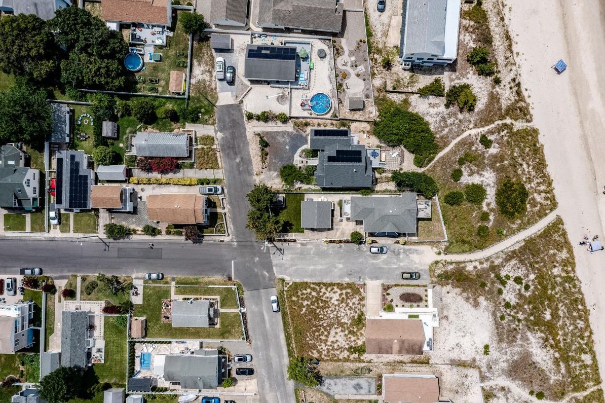 Top-down aerial of a street ending at the beach