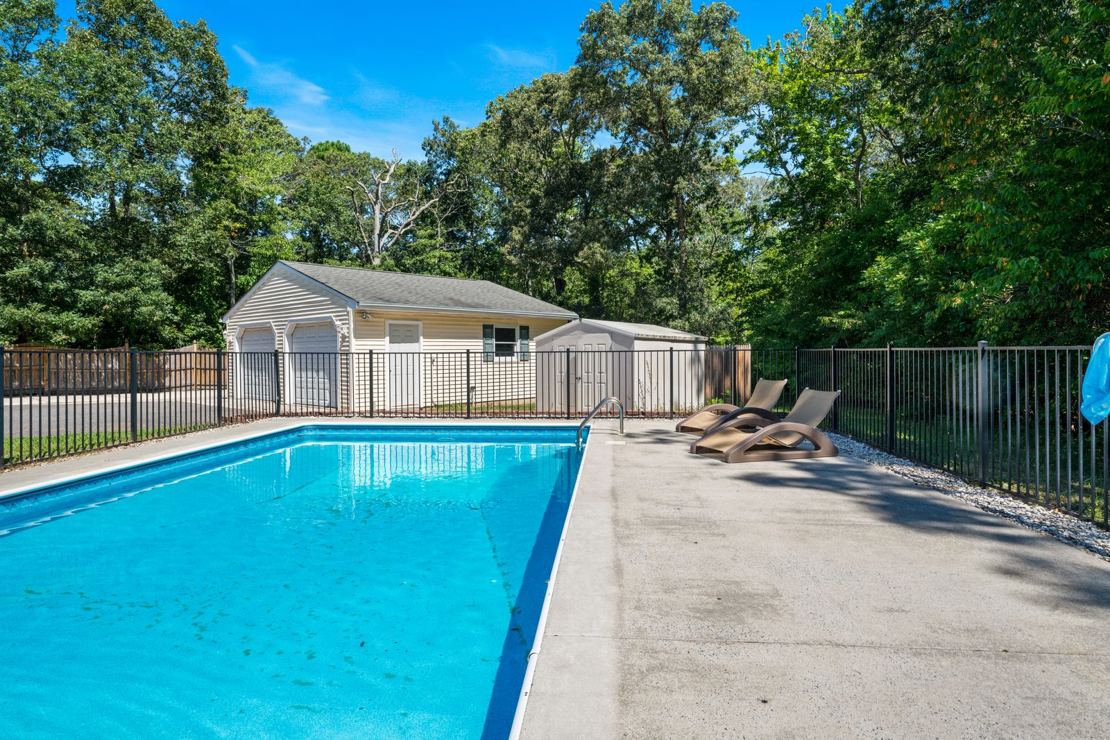 Inground pool with fence and lounge area