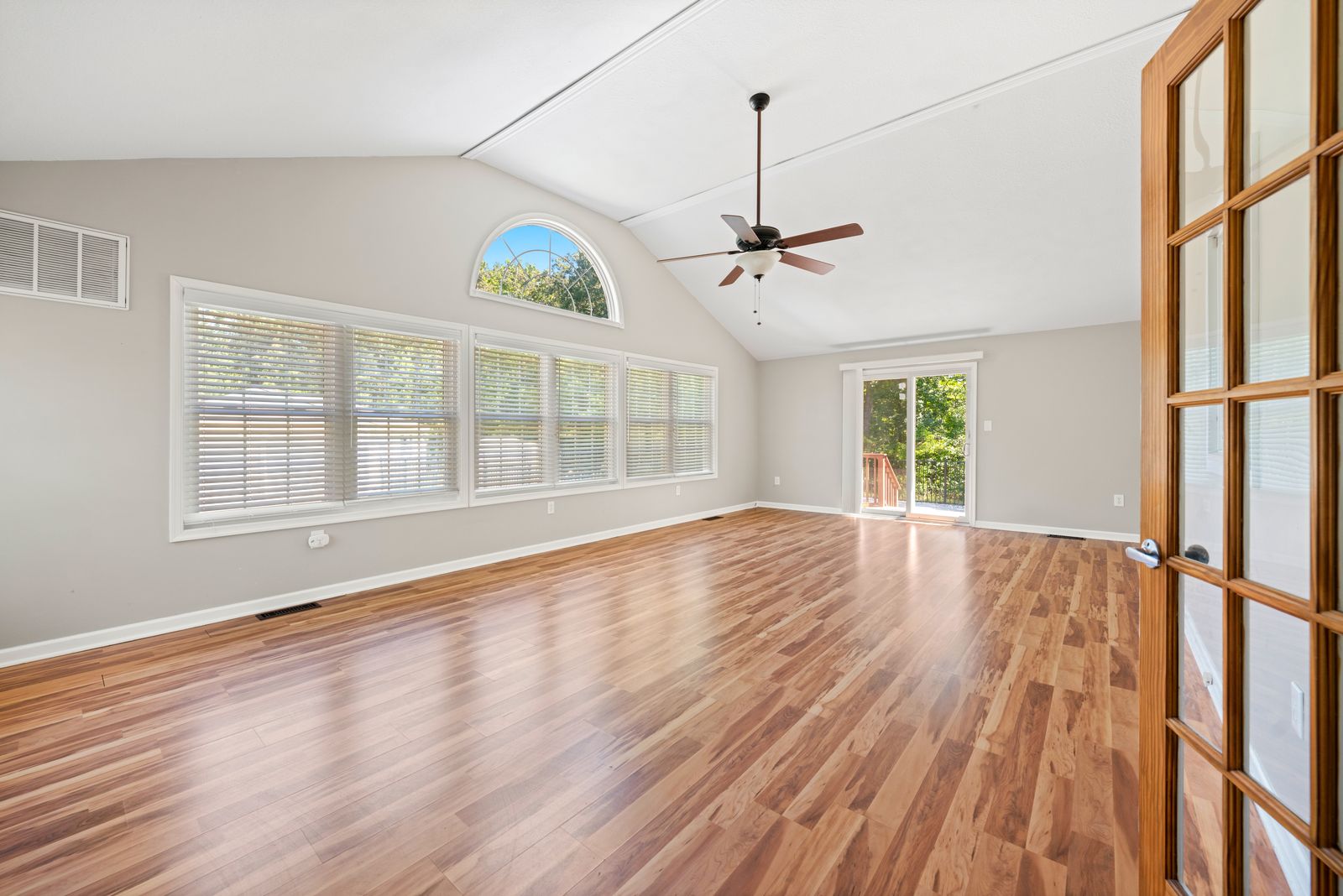 Bright great room with vaulted ceiling and arched window