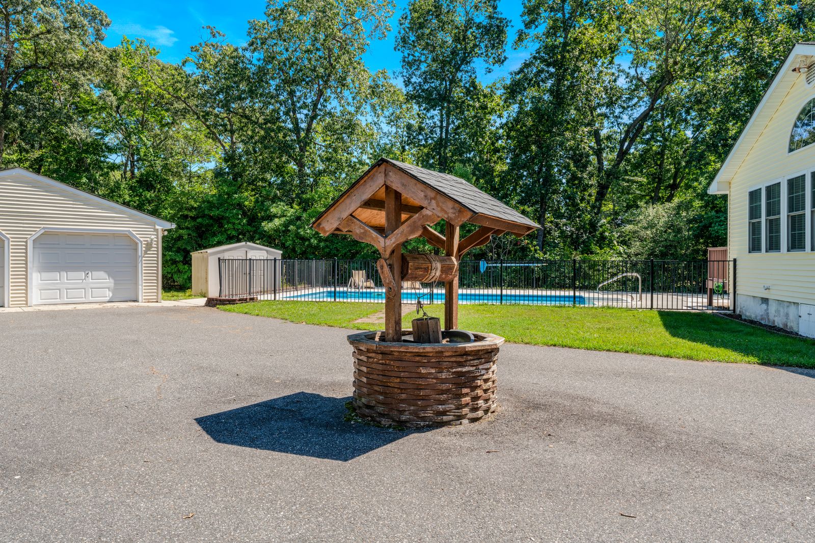 Wishing well and driveway leading to the garage and pool