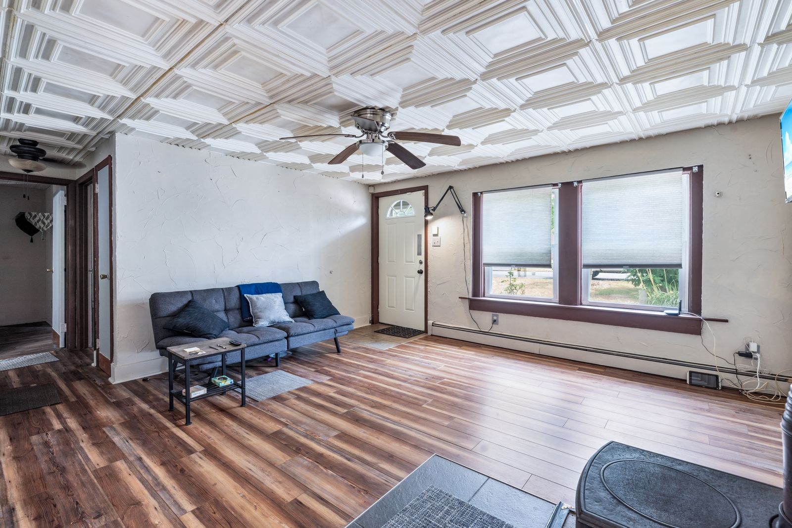 Living room with pressed-tin style ceiling and wood-look floors