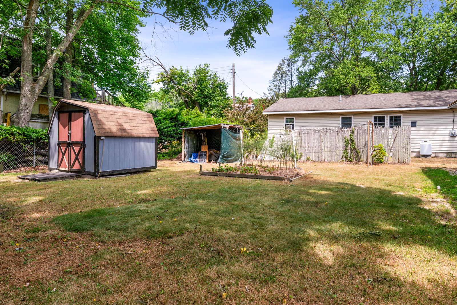 Backyard with barn-style shed and mature trees