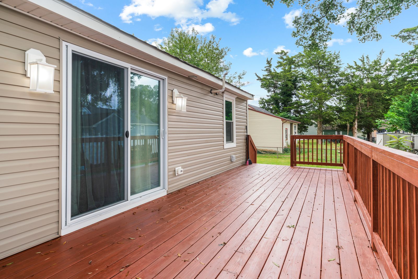 Stained wood back deck with sliding doors