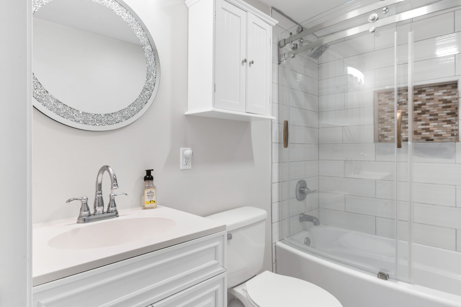 Bathroom with glass-door tub shower and subway tile