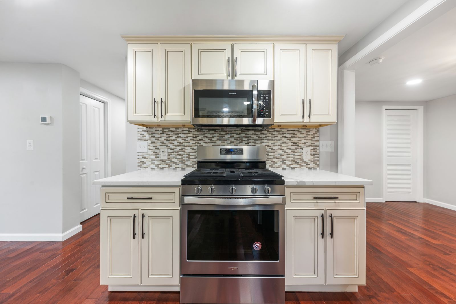 Cream cabinets and gas range in the renovated kitchen