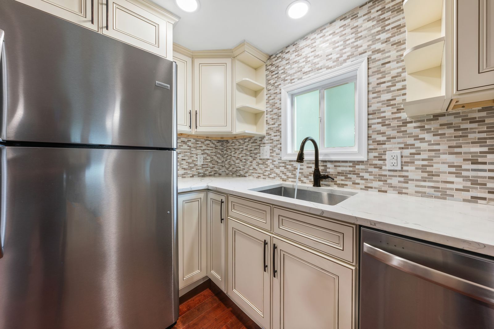 Kitchen with quartz counters, mosaic backsplash and stainless appliances