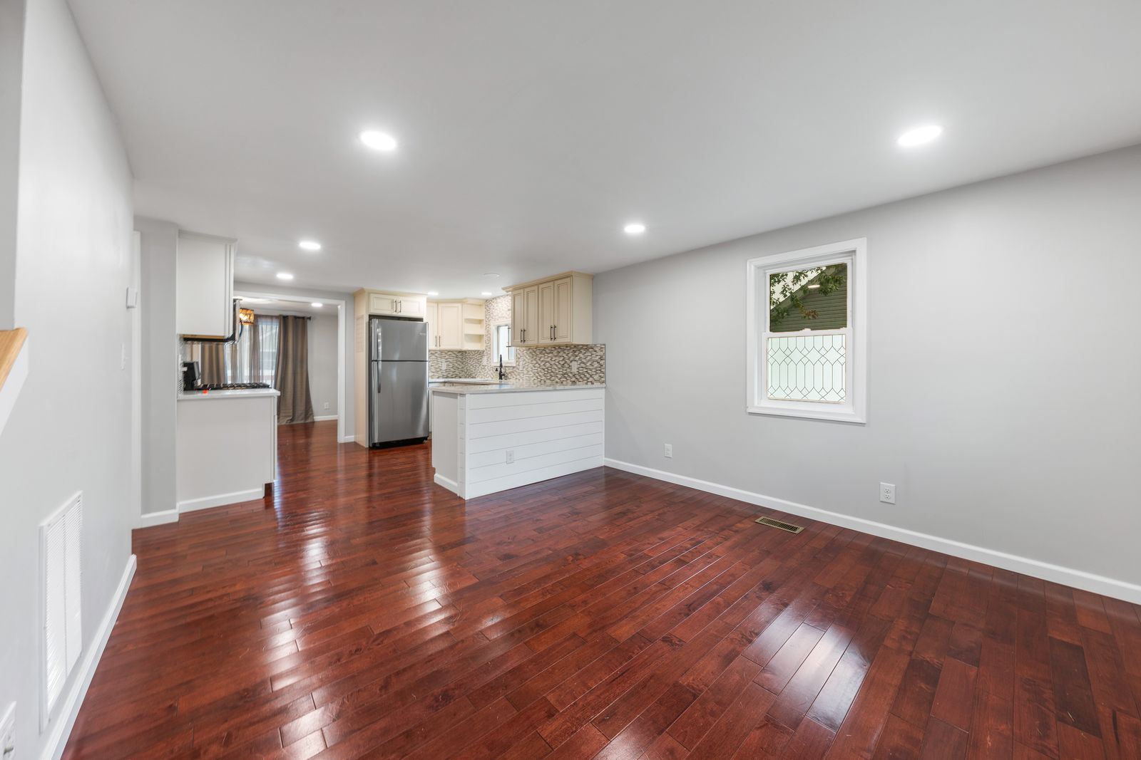 Open living space with cherry hardwood floors and recessed lighting