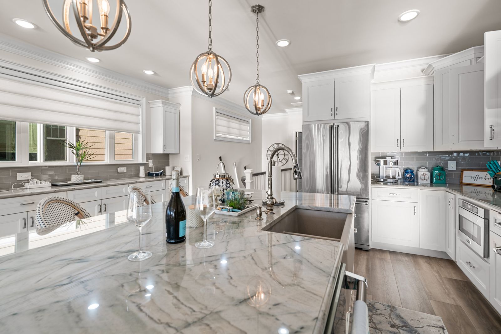 White kitchen with marble island and stainless appliances