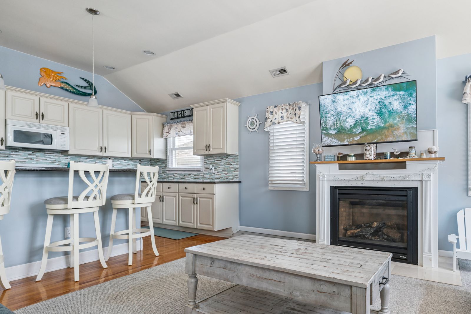 Open living room with gas fireplace and kitchen bar seating