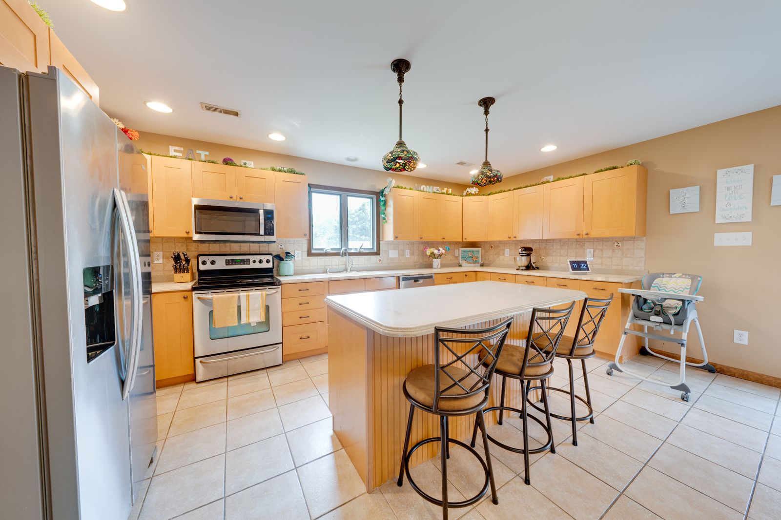 Large kitchen with maple cabinets, island and stainless appliances