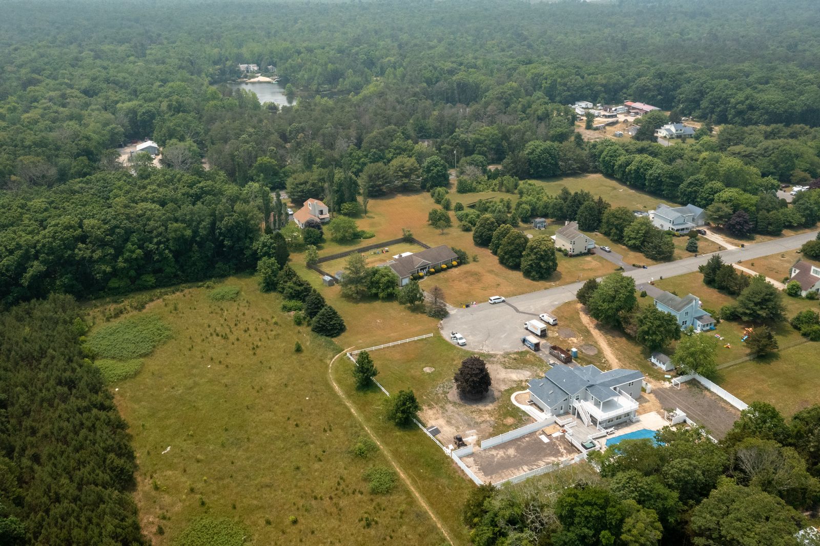 Wide aerial over woods and fields around the property