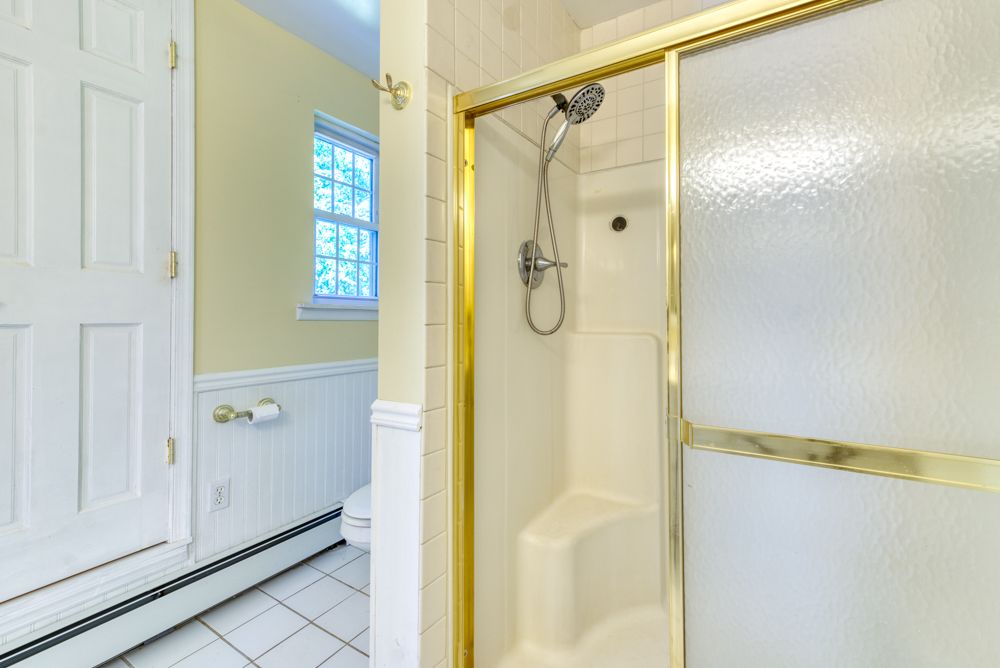 Bathroom with glass shower and wainscoting