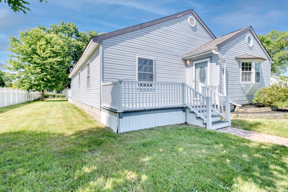 Gray cottage with front deck on a corner lot in Villas NJ