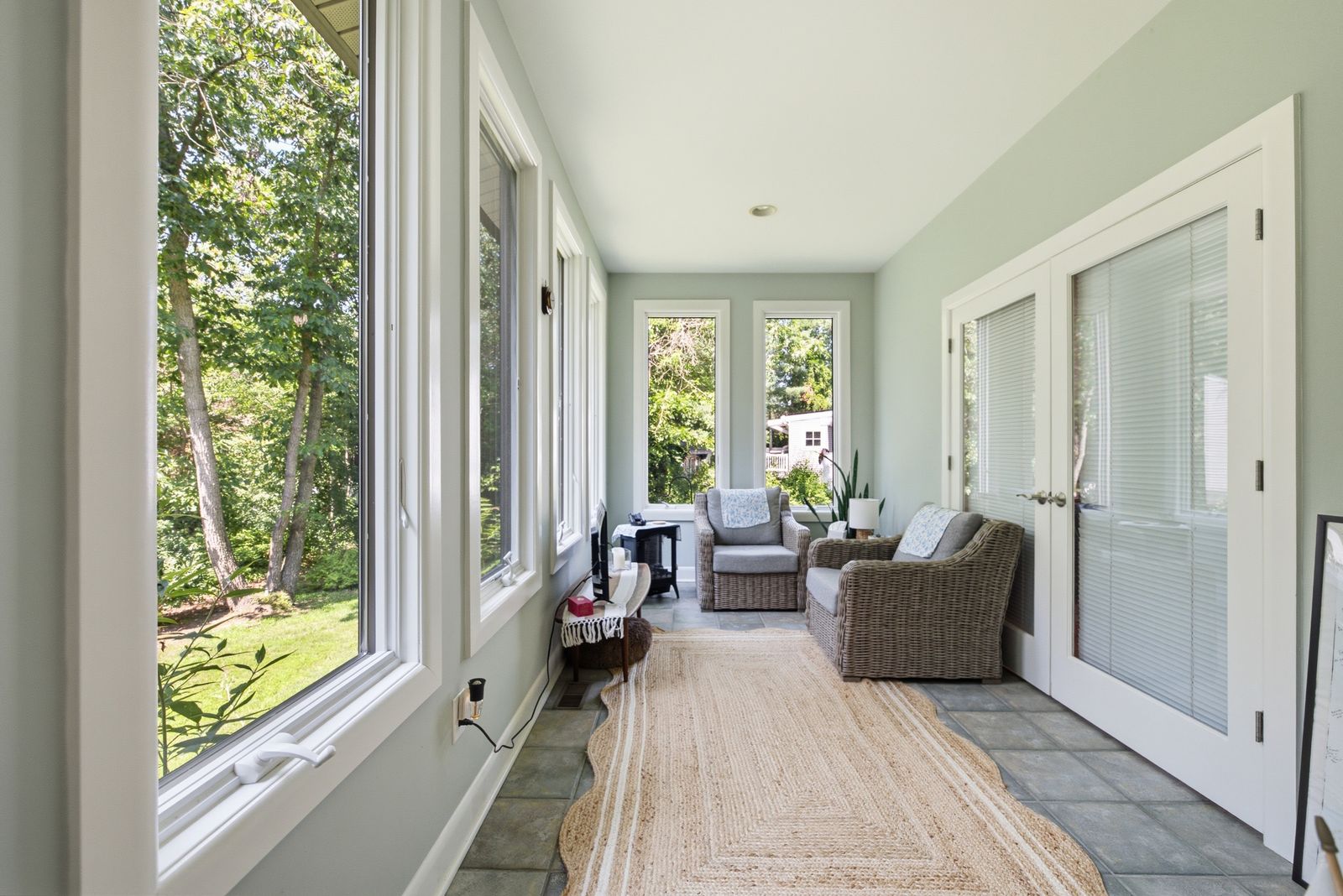 Sunroom with walls of windows facing the woods