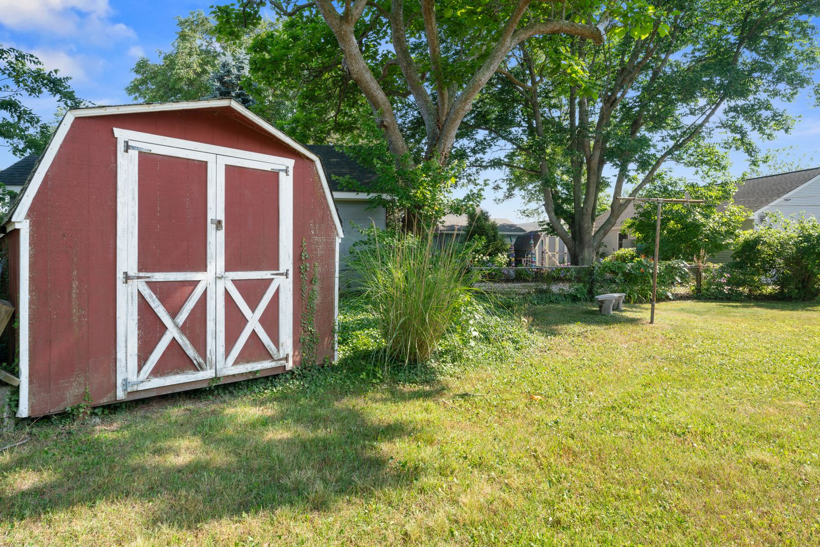 Red barn-style storage shed in the backyard