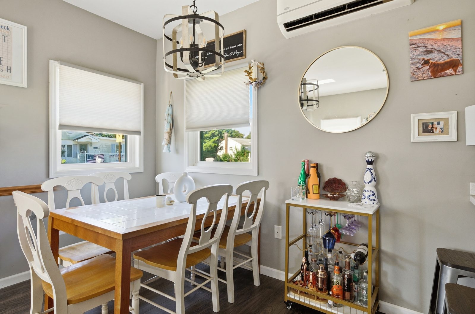 Dining room with wooden table, white chairs and bar cart