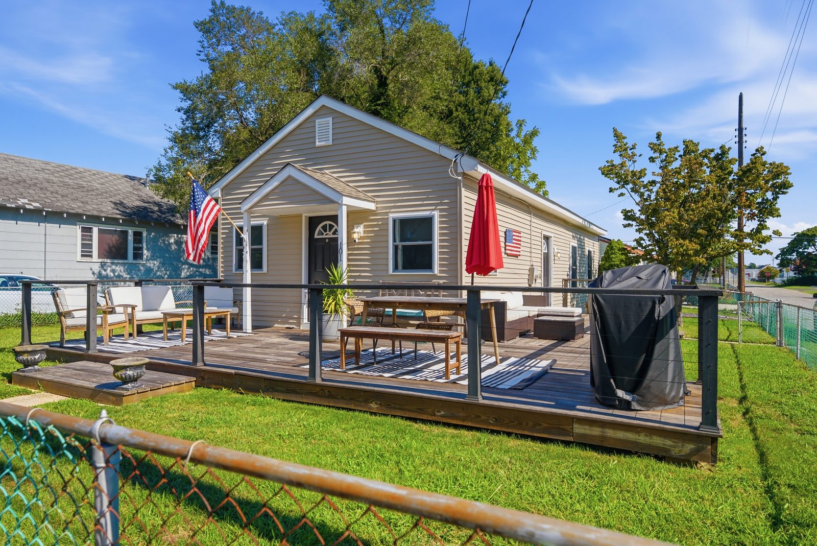 Side view of a beige bungalow with deck and fenced yard in Villas NJ